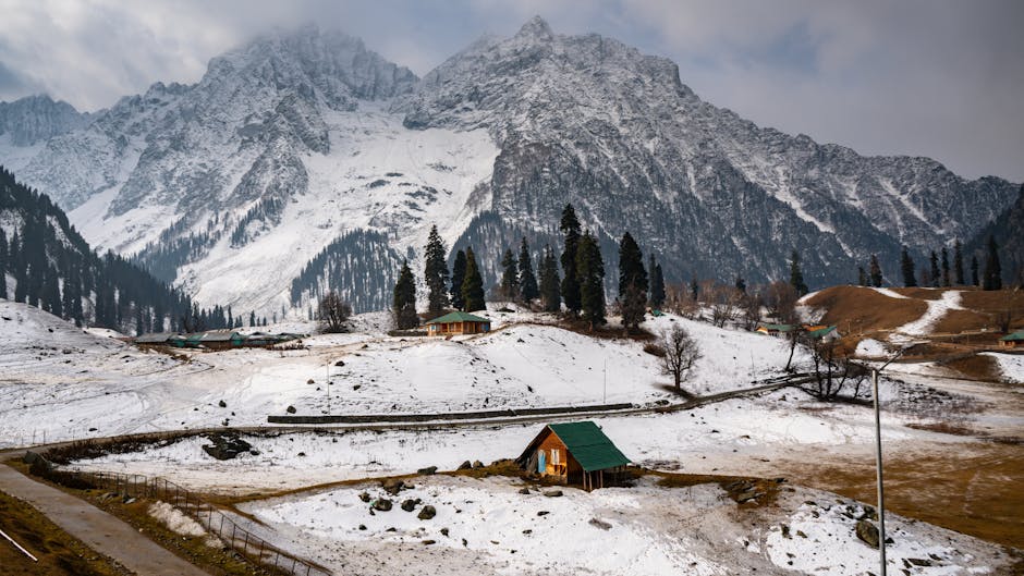 Snow-covered mountains and cabins in picturesque Sonamarg, a winter wonderland.