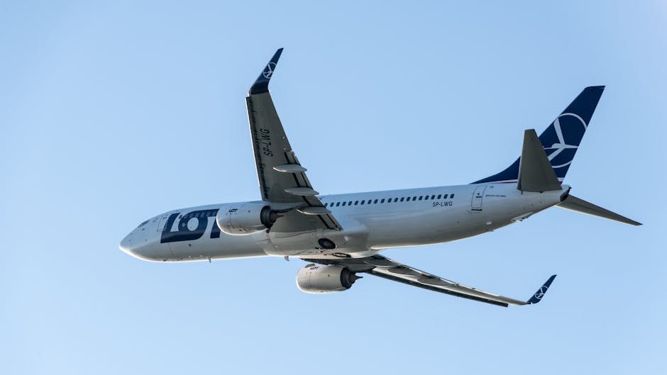 A modern commercial aircraft soaring in a clear blue sky, captured in Prague.