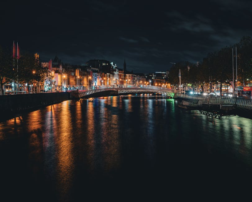 A stunning view of Dublin's Ha'penny Bridge illuminated at night over the River Liffey.